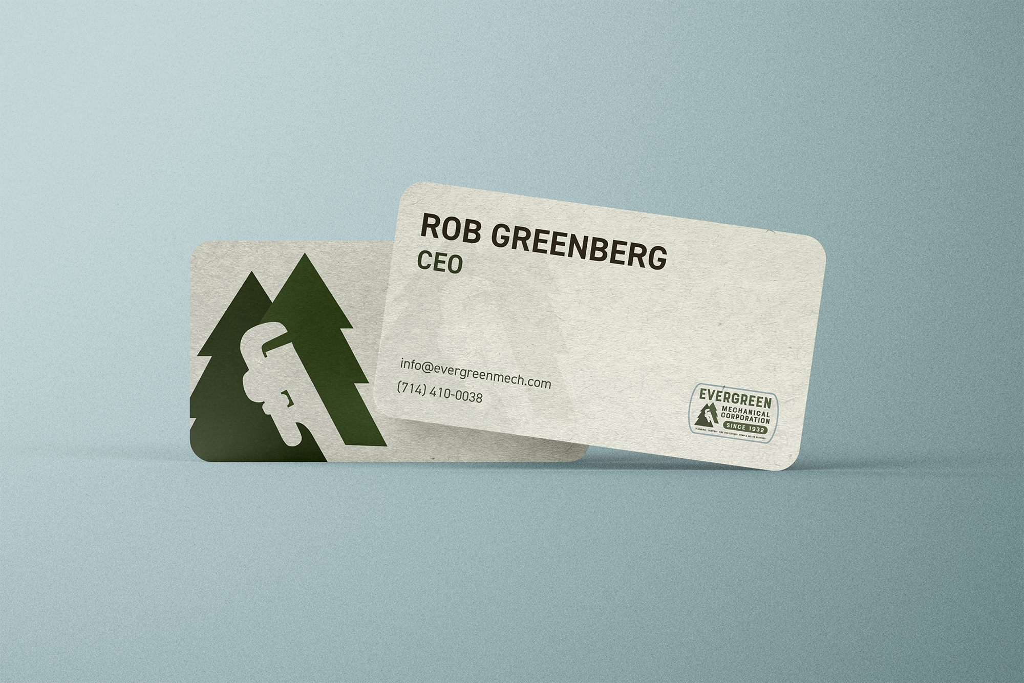 Evergreen Mechanical business cards with the symbol logo (a wrench cut out of two trees) on the front.